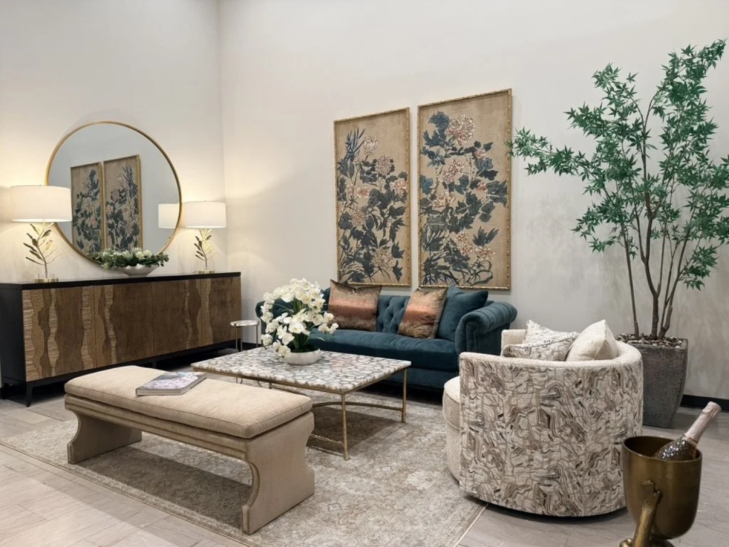 A private suite at Union Station furnished by Seville Home: a teal velvet sofa, a patterned swivel chair and botanical art