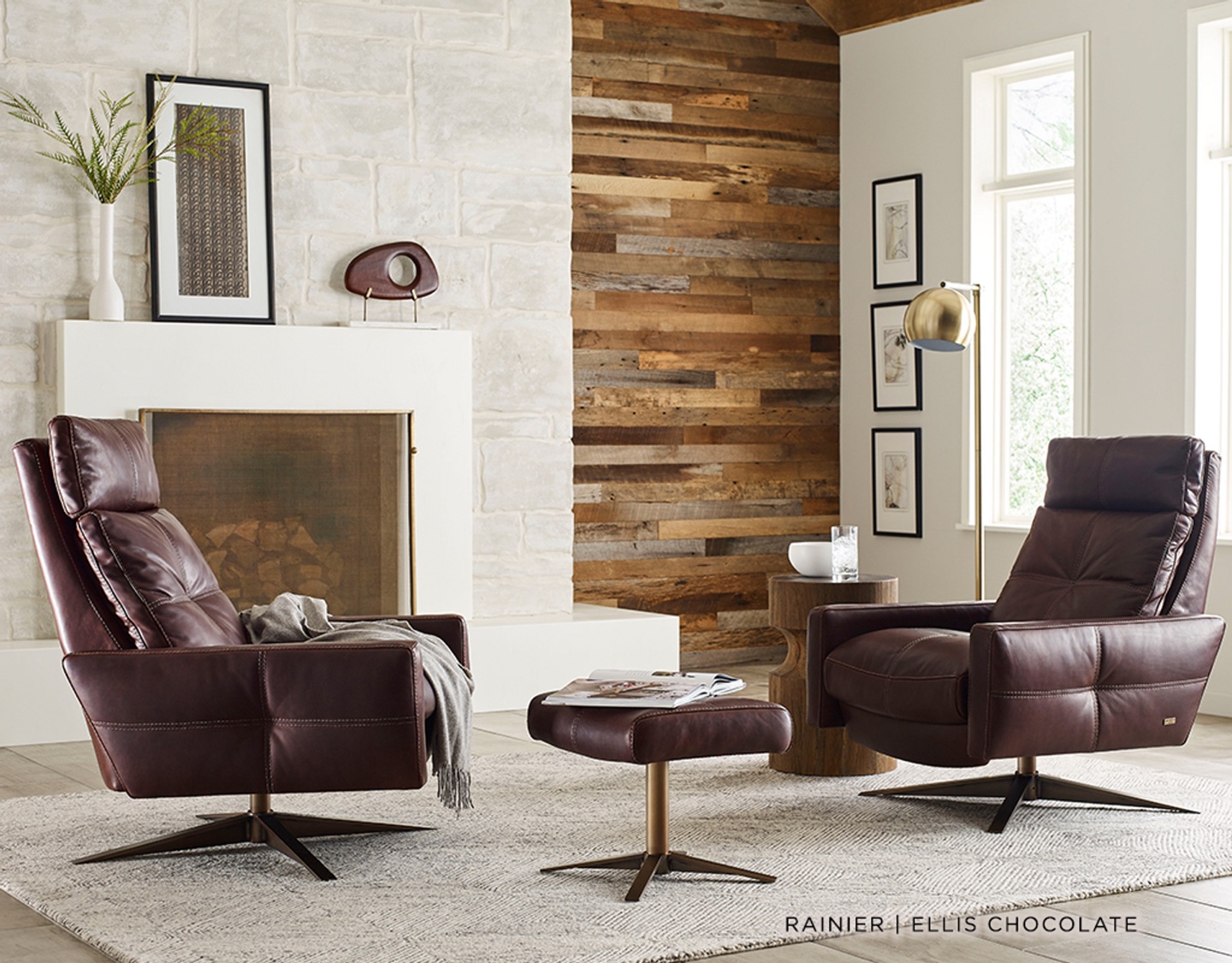 A modern living room with a low-profile leather sofa, sculptural lounge chair, and floor-to-ceiling windows.