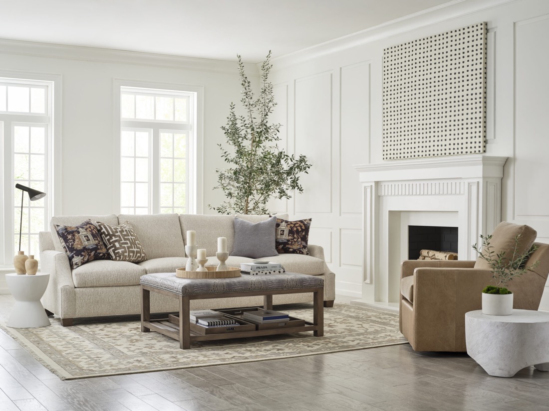 A designer-styled living room with a curved sofa, layered textiles, and a sculptural cocktail table.