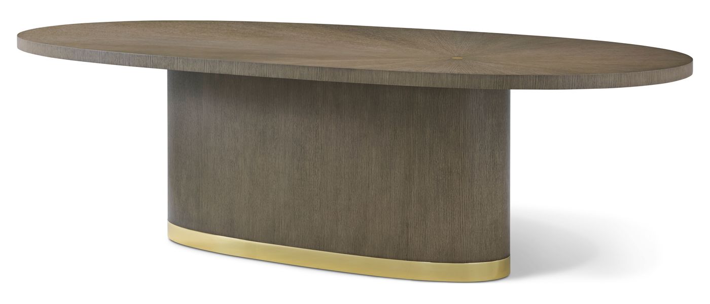 The Theodore Alexander Judith Leiber Couture oval dining table: a starburst oak top on a plinth base banded in brass.